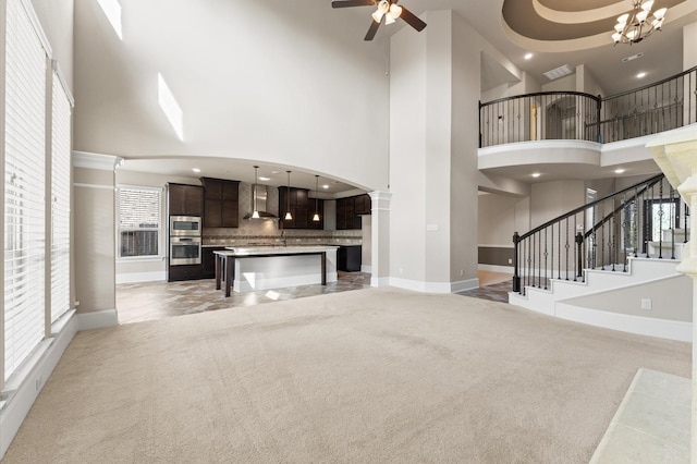 10115 Cypress Path, Missouri City, TX 77459 - unfurnished living room with a towering ceiling, baseboards, light colored carpet, a ceiling fan, and stairs