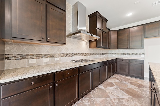 10115 Cypress Path, Missouri City, TX 77459 - kitchen with wall chimney exhaust hood, dark brown cabinets, light stone countertops, and stainless steel gas stovetop
