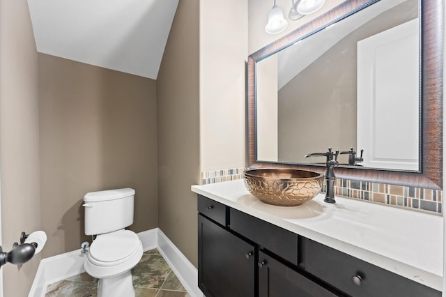 10115 Cypress Path, Missouri City, TX 77459 - bathroom featuring baseboards, toilet, vanity, lofted ceiling, and decorative backsplash