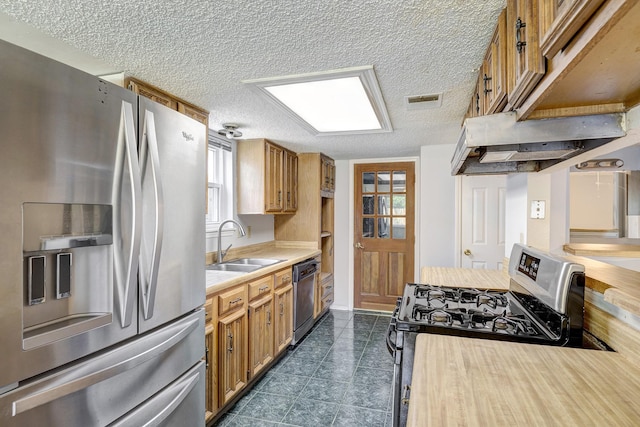 3826 Brier Gardens Dr, Houston, TX 77082 - kitchen featuring appliances with stainless steel finishes, a sink, light countertops, brown cabinets, and a textured ceiling