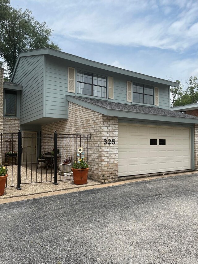 325 E Main St, Brenham, TX 77833 - view of front of house featuring brick siding, driveway, and a garage