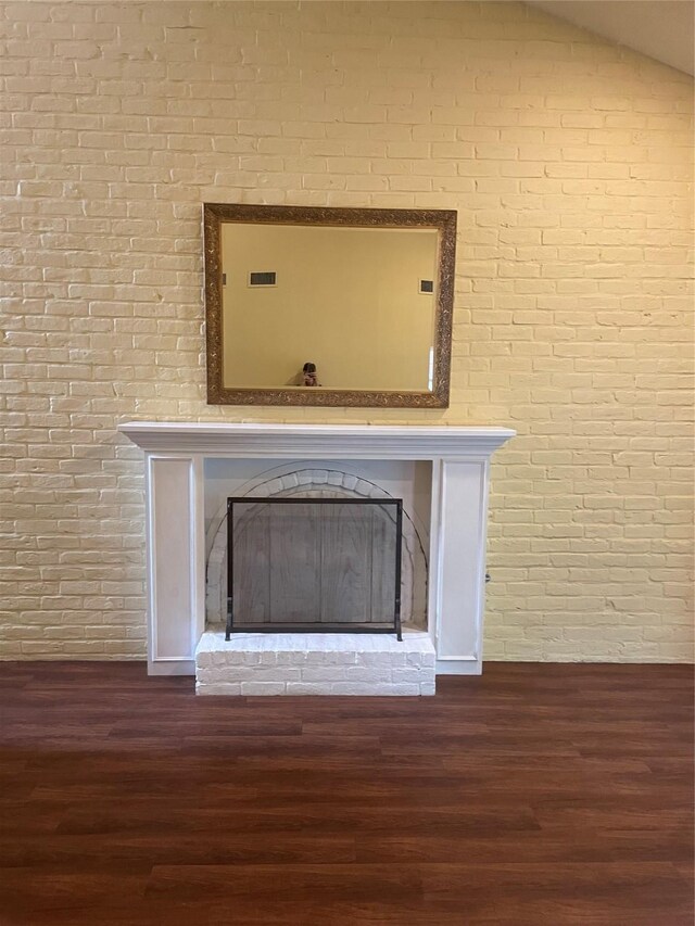 325 E Main St, Brenham, TX 77833 - detailed view of a fireplace with raised hearth, brick wall, and wood finished floors