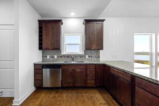 2811 Izamal Ct, Galveston, TX 77554 - kitchen with stainless steel dishwasher, a sink, dark wood-style flooring, tasteful backsplash, and recessed lighting
