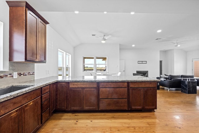 2811 Izamal Ct, Galveston, TX 77554 - kitchen with a ceiling fan, light stone countertops, open floor plan, backsplash, and lofted ceiling