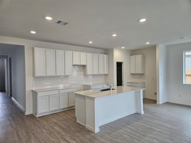 349 Tejas Trl, Waller, TX 77484 - kitchen featuring an island with sink, decorative backsplash, light wood-type flooring, white cabinets, and recessed lighting