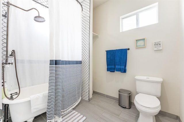 1828 Ursuline St, Galveston, TX 77550 - bathroom featuring toilet, baseboards, shower / tub combo with curtain, and tile patterned floors