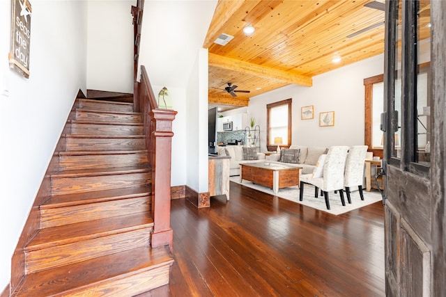 1828 Ursuline St, Galveston, TX 77550 - stairs featuring hardwood / wood-style floors, a ceiling fan, wooden ceiling with exposed beams, and a stone fireplace