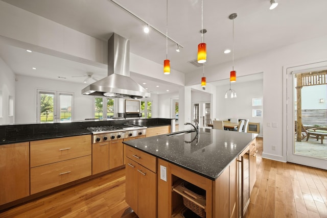 3810 Bellefontaine St, Houston, TX 77025 - kitchen with stainless steel gas cooktop, island exhaust hood, a sink, light wood-type flooring, and recessed lighting