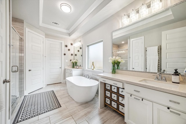 8826 Forest Side Dr, Missouri City, TX 77459 - bathroom featuring a stall shower, two vanities, a soaking tub, and a raised ceiling