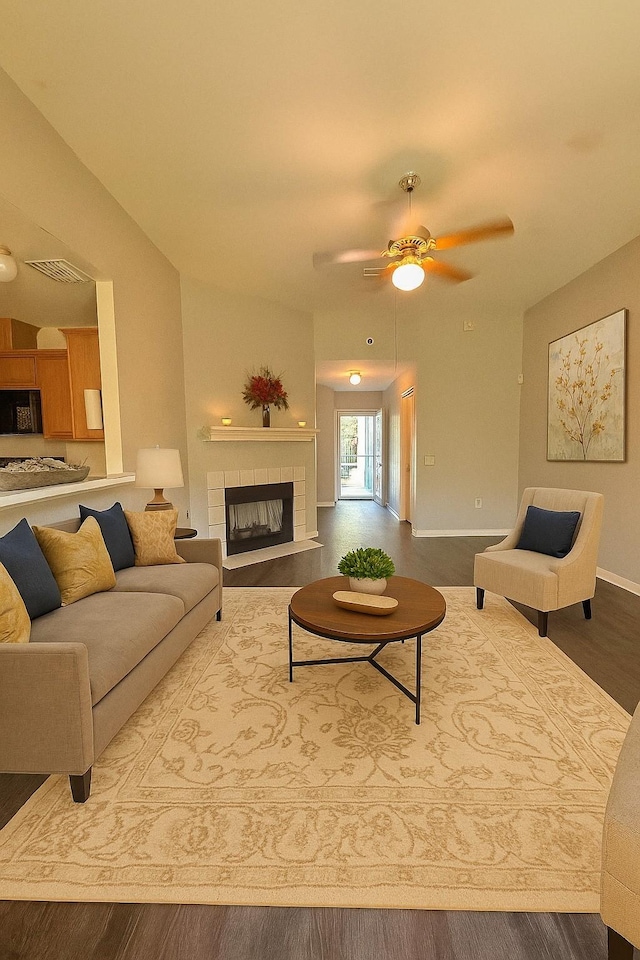 7340 Muffin Dr, Austin, TX 78724 - living area with a tile fireplace, wood finished floors, ceiling fan, and baseboards