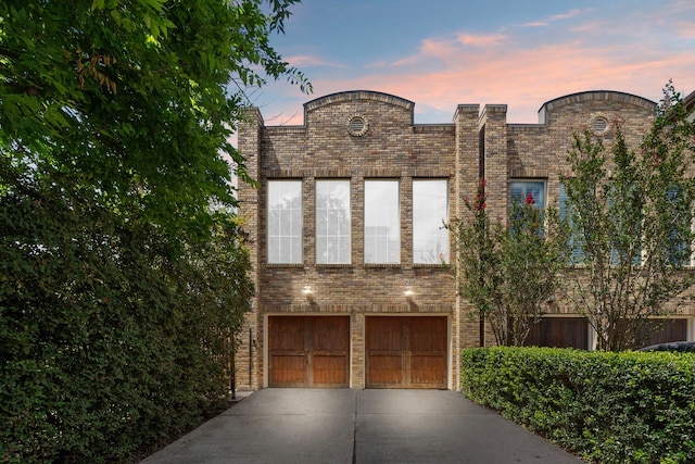 1226 Peden St, Houston, TX 77006 - view of front facade featuring a garage, concrete driveway, and brick siding