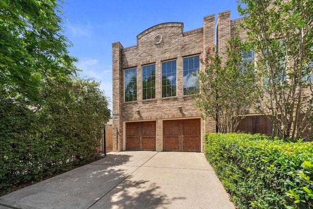 1226 Peden St, Houston, TX 77006 - view of front facade with concrete driveway, a garage, and brick siding