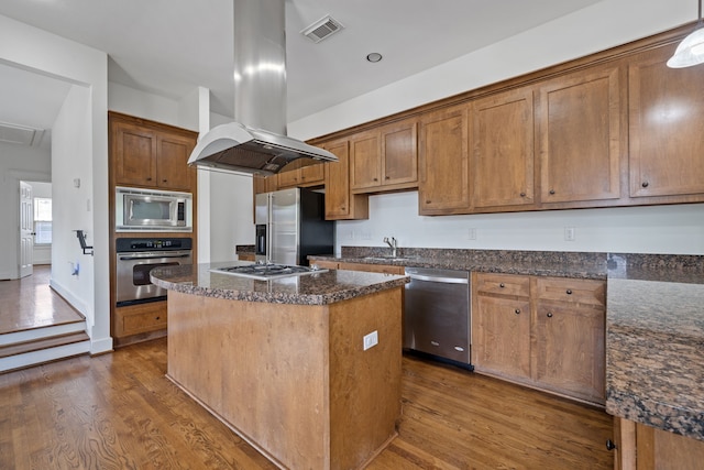 1226 Peden St, Houston, TX 77006 - kitchen featuring appliances with stainless steel finishes, island range hood, dark wood-type flooring, and a center island