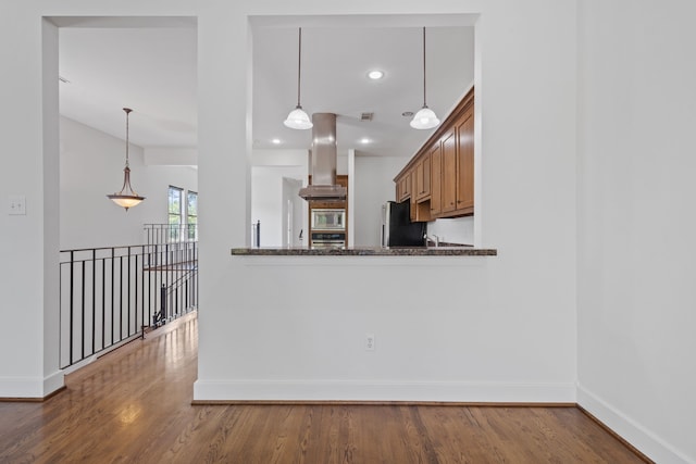 1226 Peden St, Houston, TX 77006 - kitchen featuring island range hood, stainless steel appliances, baseboards, wood finished floors, and hanging light fixtures