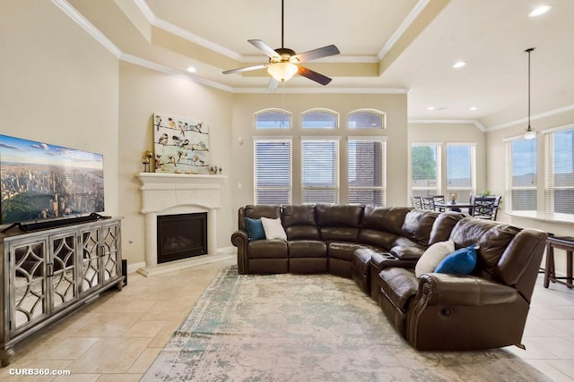 1522 Richland Hollow Ln, Friendswood, TX 77546 - living room with a tray ceiling, ceiling fan, crown molding, light tile patterned flooring, and a fireplace with raised hearth