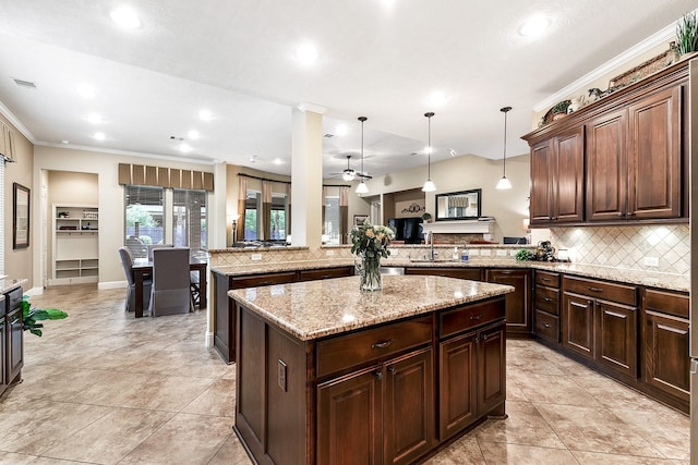 5702 Mustang Ridge Ln, Fulshear, TX 77441 - kitchen with a peninsula, a center island, decorative backsplash, crown molding, and recessed lighting