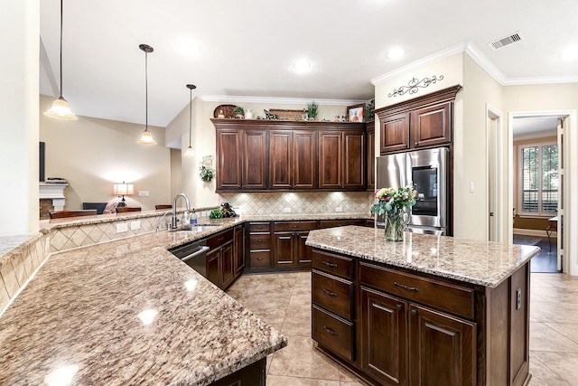 5702 Mustang Ridge Ln, Fulshear, TX 77441 - kitchen featuring appliances with stainless steel finishes, a sink, dark brown cabinets, tasteful backsplash, and light tile patterned floors
