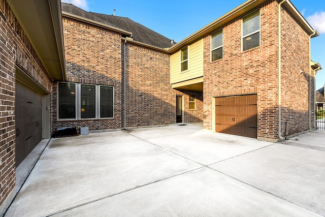 5702 Mustang Ridge Ln, Fulshear, TX 77441 - rear view of property with brick siding, an attached garage, and driveway