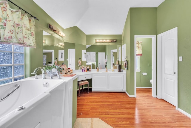 17503 Whispering Star Ct, Houston, TX 77095 - full bath with vanity, a bath, toilet, lofted ceiling, and wood finished floors