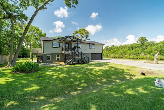 719 Fairfield St, Shoreacres, TX 77571 - view of front of home with stairway, concrete driveway, a garage, and a front yard