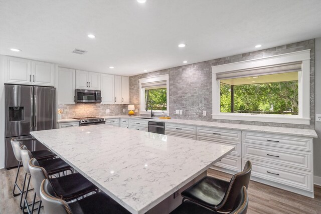 719 Fairfield St, Shoreacres, TX 77571 - kitchen featuring appliances with stainless steel finishes, a sink, light stone countertops, white cabinets, and recessed lighting