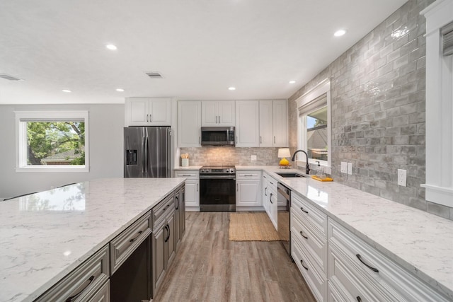 719 Fairfield St, Shoreacres, TX 77571 - kitchen featuring appliances with stainless steel finishes, a sink, tasteful backsplash, plenty of natural light, and recessed lighting