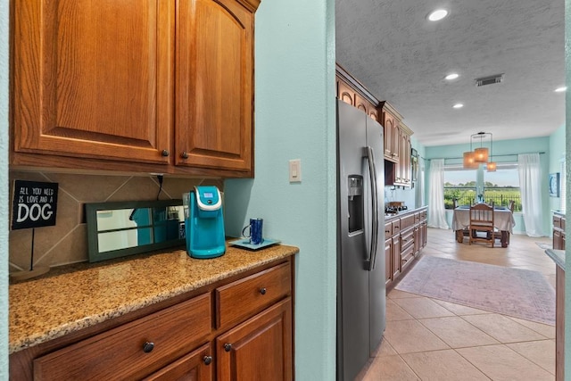 4510 Bonita Way, League City, TX 77573 - kitchen featuring stainless steel appliances, light stone counters, brown cabinetry, pendant lighting, and recessed lighting