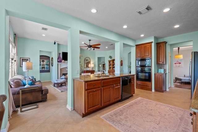 4510 Bonita Way, League City, TX 77573 - kitchen with black appliances, open floor plan, brown cabinets, a sink, and a fireplace
