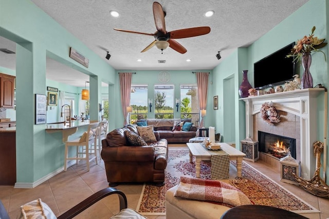 4510 Bonita Way, League City, TX 77573 - living room featuring light tile patterned flooring, a ceiling fan, a fireplace, a textured ceiling, and recessed lighting