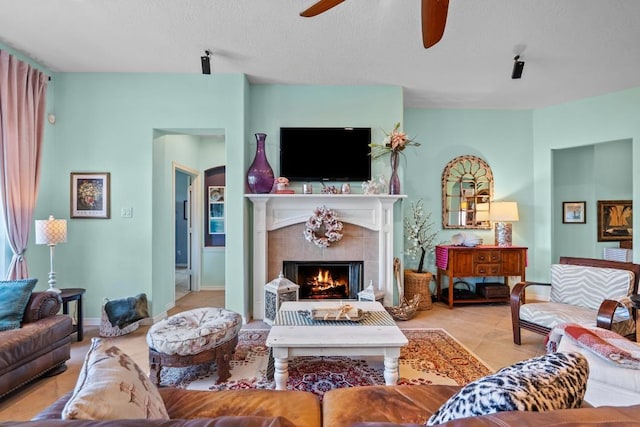 4510 Bonita Way, League City, TX 77573 - living room with ceiling fan, a tile fireplace, tile patterned flooring, and a textured ceiling