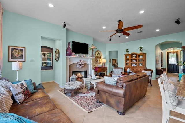 4510 Bonita Way, League City, TX 77573 - living room featuring arched walkways, light tile patterned flooring, recessed lighting, a tiled fireplace, and ceiling fan