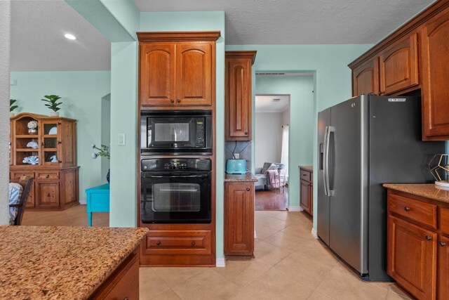 4510 Bonita Way, League City, TX 77573 - kitchen featuring black appliances, light stone countertops, light tile patterned floors, brown cabinets, and recessed lighting
