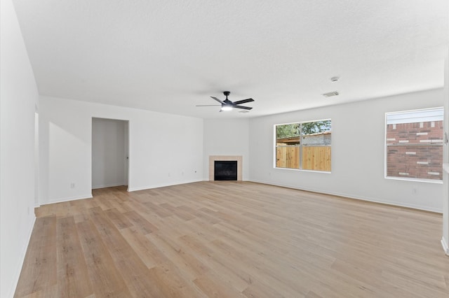 2411 Irish Spring Dr, Houston, TX 77067 - unfurnished living room featuring light wood finished floors, ceiling fan, baseboards, and a fireplace