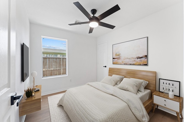 2411 Irish Spring Dr, Houston, TX 77067 - bedroom with wood finished floors, a ceiling fan, and baseboards