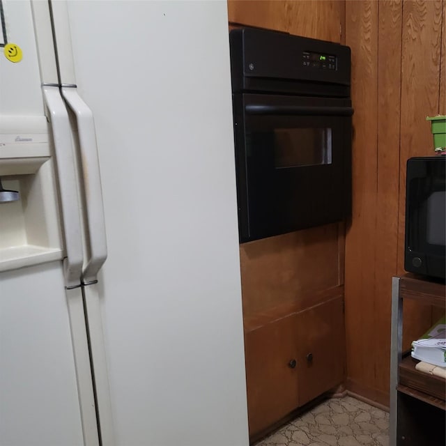 119 Poppy St SE, Lake Jackson, TX 77566 - kitchen featuring black appliances, wood walls, and brown cabinets