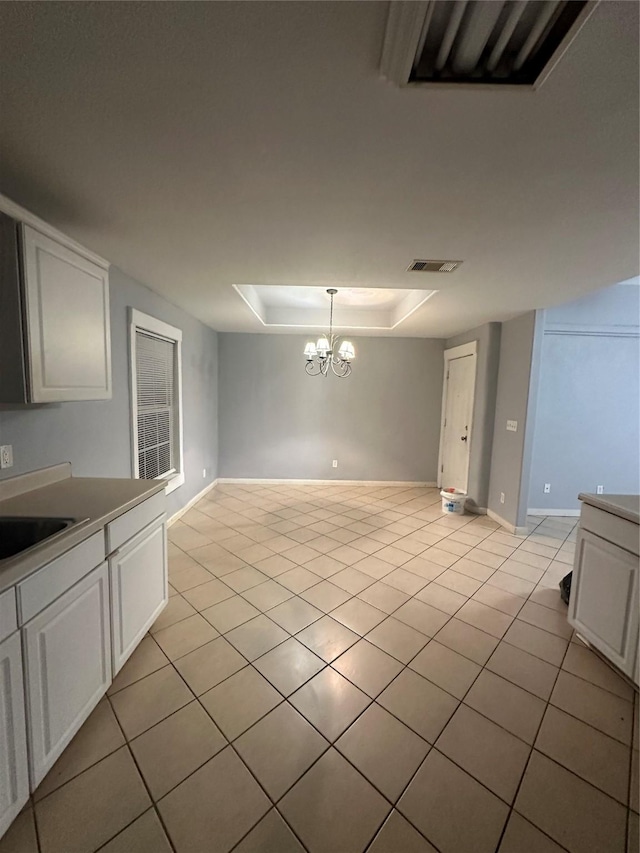 227 S Brownell St, La Porte, TX 77571 - unfurnished dining area with light tile patterned flooring, a chandelier, a raised ceiling, a sink, and baseboards