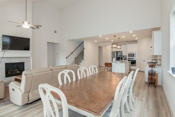 11211 Stirton, Tomball, TX 77375 - dining area featuring light wood finished floors, stairs, high vaulted ceiling, recessed lighting, and a ceiling fan
