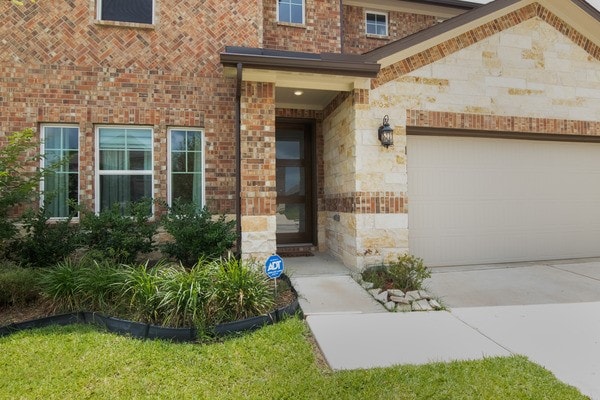 11211 Stirton, Tomball, TX 77375 - view of exterior entry with brick siding, driveway, and stone siding