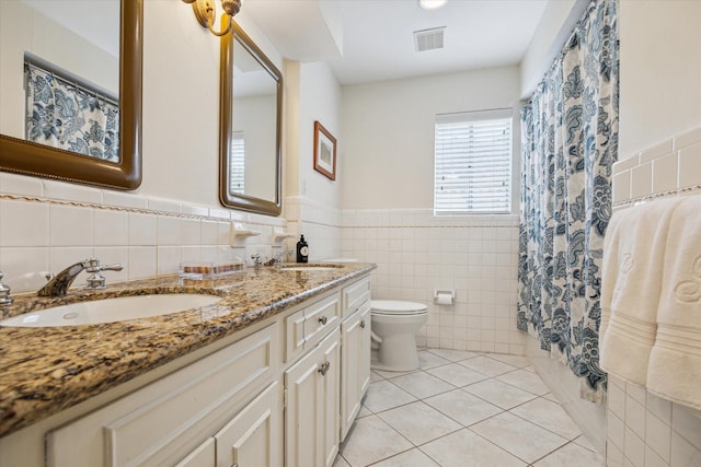 2910 Ann Arbor Dr, Houston, TX 77063 - full bath with tile walls, double vanity, toilet, tile patterned flooring, and wainscoting