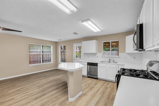 5514 Clarkston Ln, Spring, TX 77379 - kitchen with appliances with stainless steel finishes, light wood-style flooring, a sink, a textured ceiling, and healthy amount of natural light