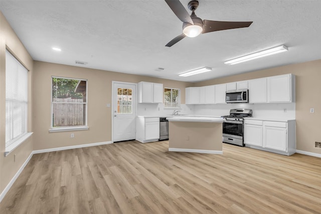 5514 Clarkston Ln, Spring, TX 77379 - kitchen with appliances with stainless steel finishes, light countertops, light wood-style flooring, white cabinets, and baseboards