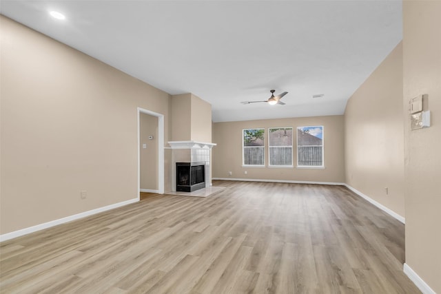 5514 Clarkston Ln, Spring, TX 77379 - unfurnished living room featuring light wood-type flooring, a tile fireplace, baseboards, and ceiling fan