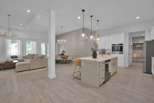 4792 W Fork Blvd, Conroe, TX 77304 - kitchen featuring a chandelier, appliances with stainless steel finishes, white cabinetry, a breakfast bar area, and a kitchen island