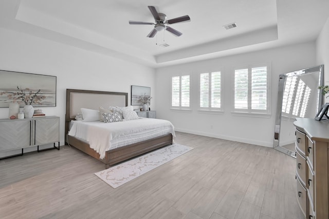 4792 W Fork Blvd, Conroe, TX 77304 - bedroom featuring a raised ceiling, light wood-style flooring, baseboards, and a ceiling fan