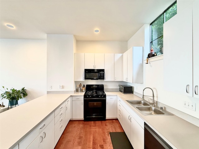 939 Colorado St Unit 8, Houston, TX 77007 - kitchen with black appliances, a sink, light countertops, wood finished floors, and recessed lighting