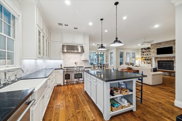 6225 Piping Rock Ln, Houston, TX 77057 - kitchen featuring double oven range, wall chimney exhaust hood, a kitchen island, white cabinets, and recessed lighting