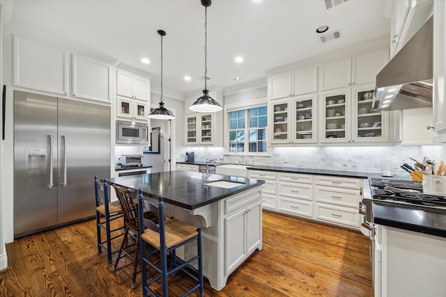6225 Piping Rock Ln, Houston, TX 77057 - kitchen featuring built in appliances, under cabinet range hood, a sink, decorative backsplash, and white cabinets