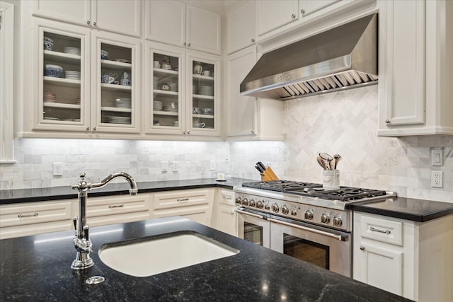 6225 Piping Rock Ln, Houston, TX 77057 - kitchen with wall chimney exhaust hood, double oven range, a sink, dark stone counters, and white cabinetry
