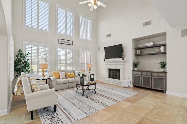 8503 Stones Throw Ln, Missouri City, TX 77459 - living room featuring a towering ceiling, baseboards, a glass covered fireplace, and a ceiling fan
