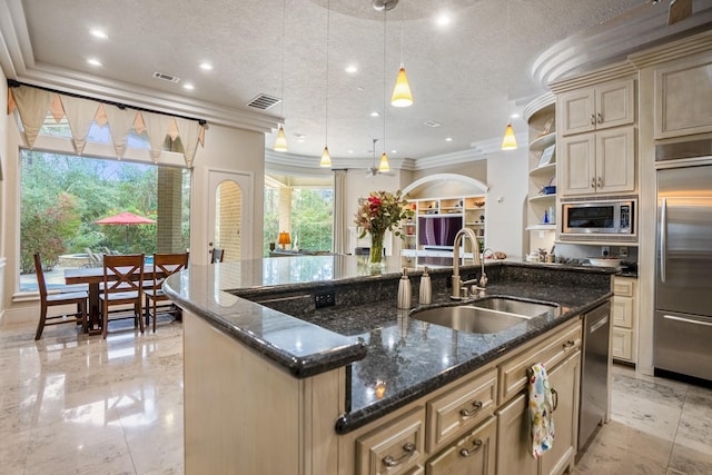11 Bracebridge Dr, The Woodlands, TX 77382 - kitchen with a sink, built in appliances, cream cabinetry, ornamental molding, and a kitchen island with sink